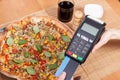 Using credit card and payment terminal for paying in restaurant, finance concept, vegetarian pizza