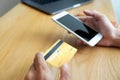 Using a credit card to pay online, use a smartphone for online shopping, a male hand holds a credit card Royalty Free Stock Photo