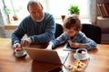 Grandfather and his grandson spending time insulated at home, stadying, watching cinema, shopping together