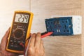 Using a digital meter to measure the voltage at an electric outlet socket box Royalty Free Stock Photo