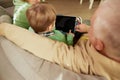 Back view of grandfather and grandson spending time together, using tablet at home. Concept of emotions, family Royalty Free Stock Photo