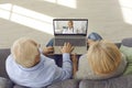 Senior couple sitting on sofa with laptop and having medical consultation with online doctor Royalty Free Stock Photo