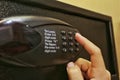 Using forefinger / index finger pushing number button on black safe to unlock safe or set password for safe.