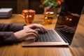 Using a gold card, a hand shops online with a laptop on a wooden table