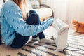 Using heater at home in winter. Woman warming her hands with cat wearing sweater. Heating season Royalty Free Stock Photo