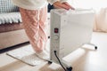 Using heater at home in winter. Woman warming her hands. Heating season. Royalty Free Stock Photo