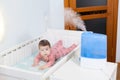 Using humidifier for newborn child comfort breathing, ultrasonic device is in bedroom Royalty Free Stock Photo