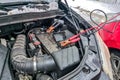 Using jumper cables to charge dead car battery during the winter season Royalty Free Stock Photo