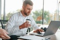 Using laptop. Man and woman are working in the modern office together Royalty Free Stock Photo