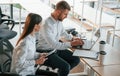 Using laptop. Man and woman are working in the modern office together Royalty Free Stock Photo