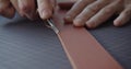 Using leather edge beveler during belt manufacturing process close-up