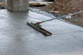 Using long trowels, a worker in a construction site leveled a wet cement sidewalk that was being poured with concrete.