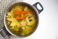 Using metal pot to cook chicken broth with meat and vegetables. Royalty Free Stock Photo