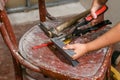 Using metal scissors, the teenager cut a small drywall profile on the chair