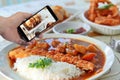 Using mobile phoe to take photo a food set for share. Selective focus. Royalty Free Stock Photo