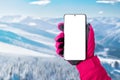 Using a mobile phone at the ski resort. Isolated display for promoting ski or mountaineering app