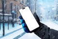 Using a mobile phone on the street while it is snowing Royalty Free Stock Photo