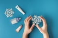 Using moisturizing hand cream during winter season. Female hands smearing white cream on the blue background next to different Royalty Free Stock Photo