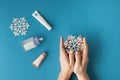 Using moisturizing hand cream during winter season. Female hands smearing white cream on the blue background next to different Royalty Free Stock Photo