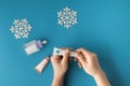 Using moisturizing hand cream during winter season. Female hands smearing white cream on the blue background next to different Royalty Free Stock Photo