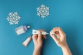 Using moisturizing hand cream during winter season. Female hands smearing white cream on the blue background next to different Royalty Free Stock Photo