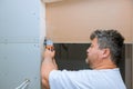 Using a multi tool, worker cuts drywall Royalty Free Stock Photo