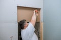 Using a multi tool worker cuts the drywall plasterboard with a cutting blade Royalty Free Stock Photo