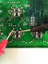 Using multimeter probes to examine a PCB