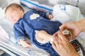 Using oximeter on newborn baby to check his level of oxygen and