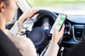 Using phone while driving car. Distracted driver texting while in vehicle. Irresponsible woman checking sms message with mobile. Royalty Free Stock Photo