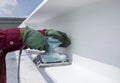 Using a Ponceuse Vibrante or Orbital Sander to scrub surface intermediate fire proof paint before painting top coat Royalty Free Stock Photo