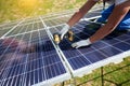 Using powerful modern drill, mounter installing solar panels on roof. Royalty Free Stock Photo