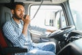 Using radio. Young truck driver is with his vehicle at daytime. Royalty Free Stock Photo