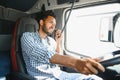 Using radio. Young truck driver is with his vehicle at daytime. Royalty Free Stock Photo