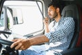 Using radio. Young truck driver is with his vehicle at daytime. Royalty Free Stock Photo