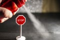 Using a red spray can with deodorant against a stop sign, environmental issue concept, soft focus Royalty Free Stock Photo