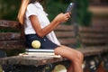 Using smartphone. School girl in uniform is outdoors near the building