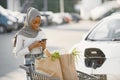 African muslim woman chraging car and use phone