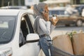 African muslim woman chraging car and use phone