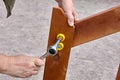 Using socket hex wrench when assembling outdoor furniture, hand of carpenter hold hexagonal key closeup. Royalty Free Stock Photo