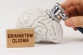 Using a stethoscope, the brain is diagnosed, next to it is a sign with the inscription - Brainstem glioma