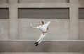 Jumping young woman in front of buildings, on the run in jump high Royalty Free Stock Photo