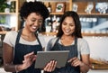 Using technology to differentiate in an increasingly competitive market. two young women using a digital tablet while Royalty Free Stock Photo