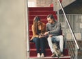 Using technology to prep for finals. Full length shot of two young university students studying while sitting on a Royalty Free Stock Photo