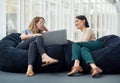 Using their proven strategies to gain the best advantages. two businesswomen using a laptop together while sitting on Royalty Free Stock Photo