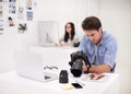 Using the tools of the trade. Two photographers sitting in their office working on layouts and inspecting their Royalty Free Stock Photo