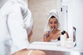 Using toothbrush. In the bathroom. Woman in white towel in head have care of herself Royalty Free Stock Photo