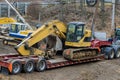 Using a trailer platform to carry heavy construction equipment on the highway is a dangerous task Royalty Free Stock Photo