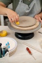 Using wooden handle sponge to smooth the surface of a clay product in a pottery workshop. Working with a sponge on a