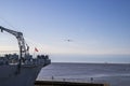 The USS Alabama battleship surrounded by the rippling waters of Mobile Bay with a pelican in flight over the ship